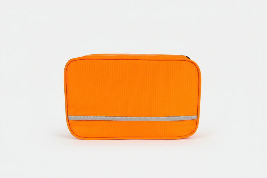 Orange toiletry bag with a white stripe on a white background