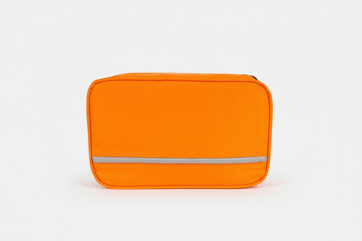 Orange toiletry bag with a white stripe on a white background