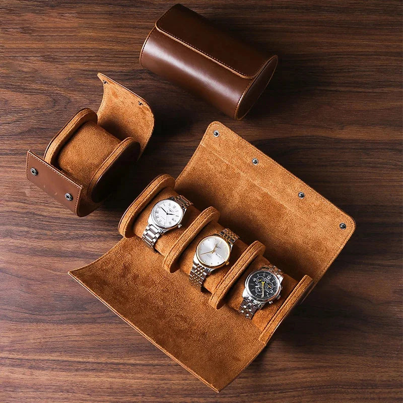 Brown leather watch case with three watches on a wooden surface
