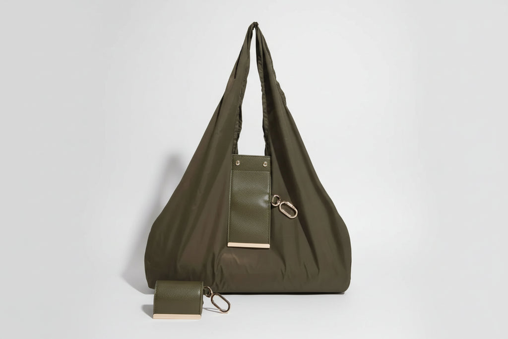 Green handbag with a pouch attached on a white background