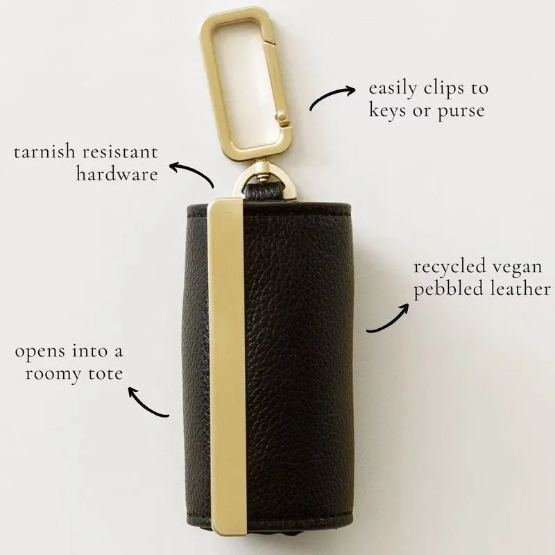 Black leather keychain with gold accents on a white background, featuring text labels about its features. Portable foldable shopping bag unfolded spacious travel tote