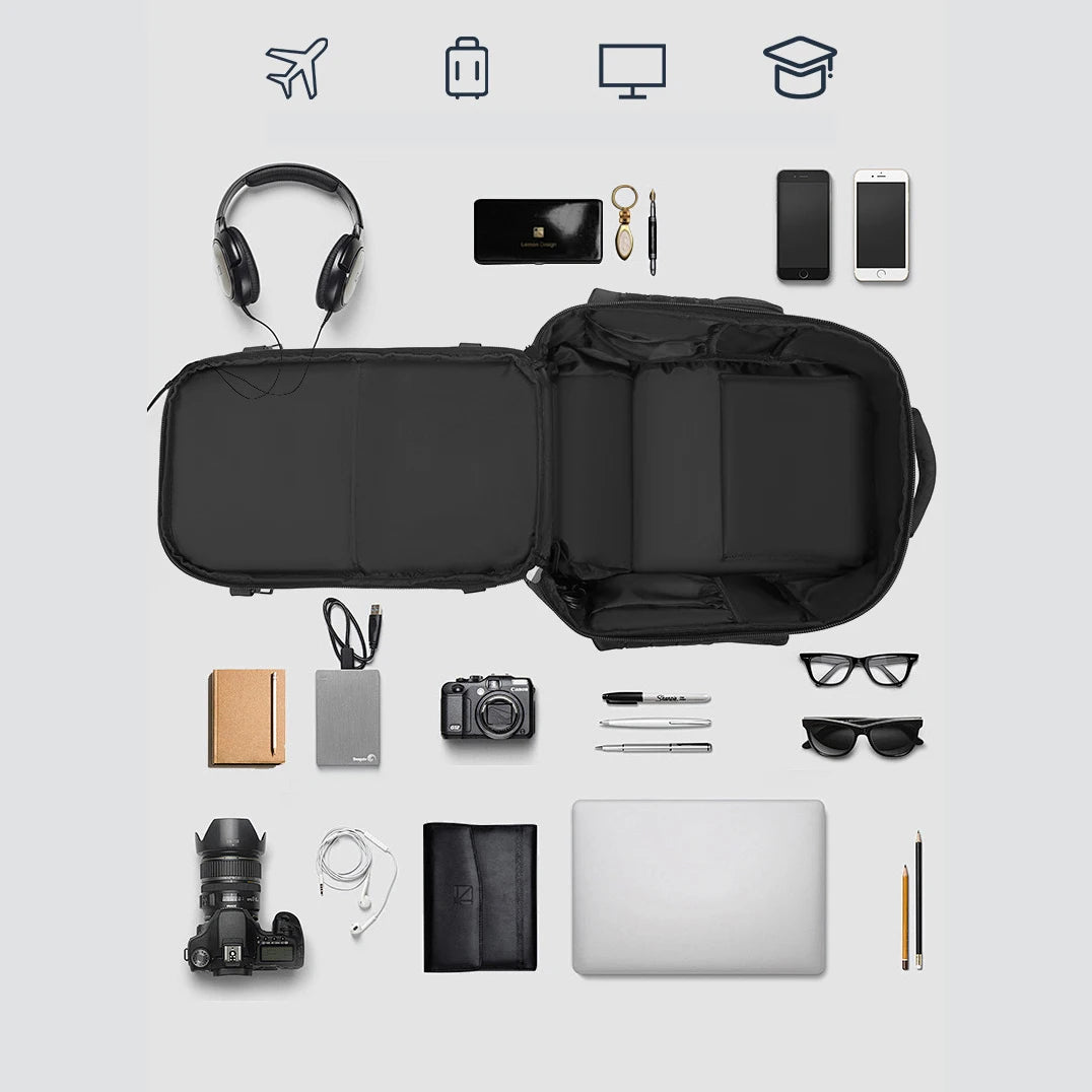 Black backpack with various travel items arranged around it on a light gray background over view