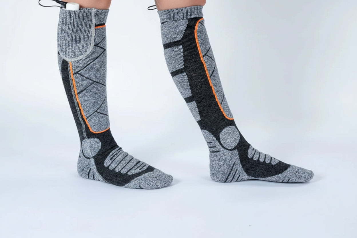 Gray and black electric heating socks with orange accents on a white background