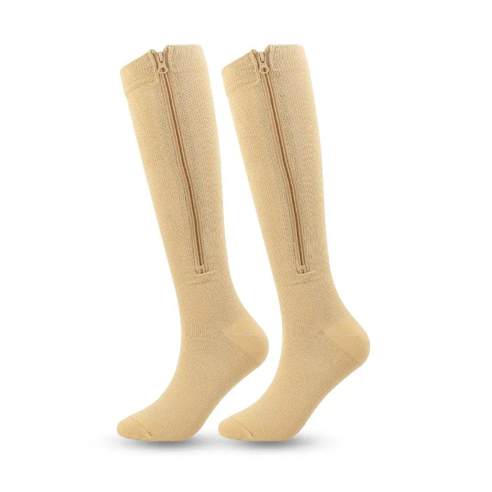 Pair of beige knee-high socks with zippers on a white background