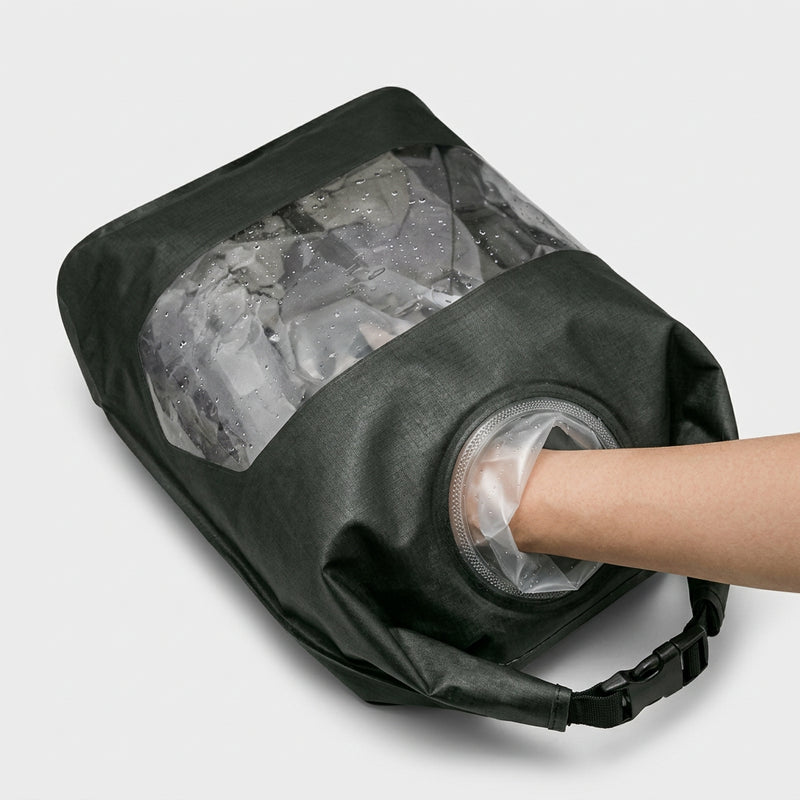 Hand washing clothes inside a portable travel wash bag through the waterproof glove port